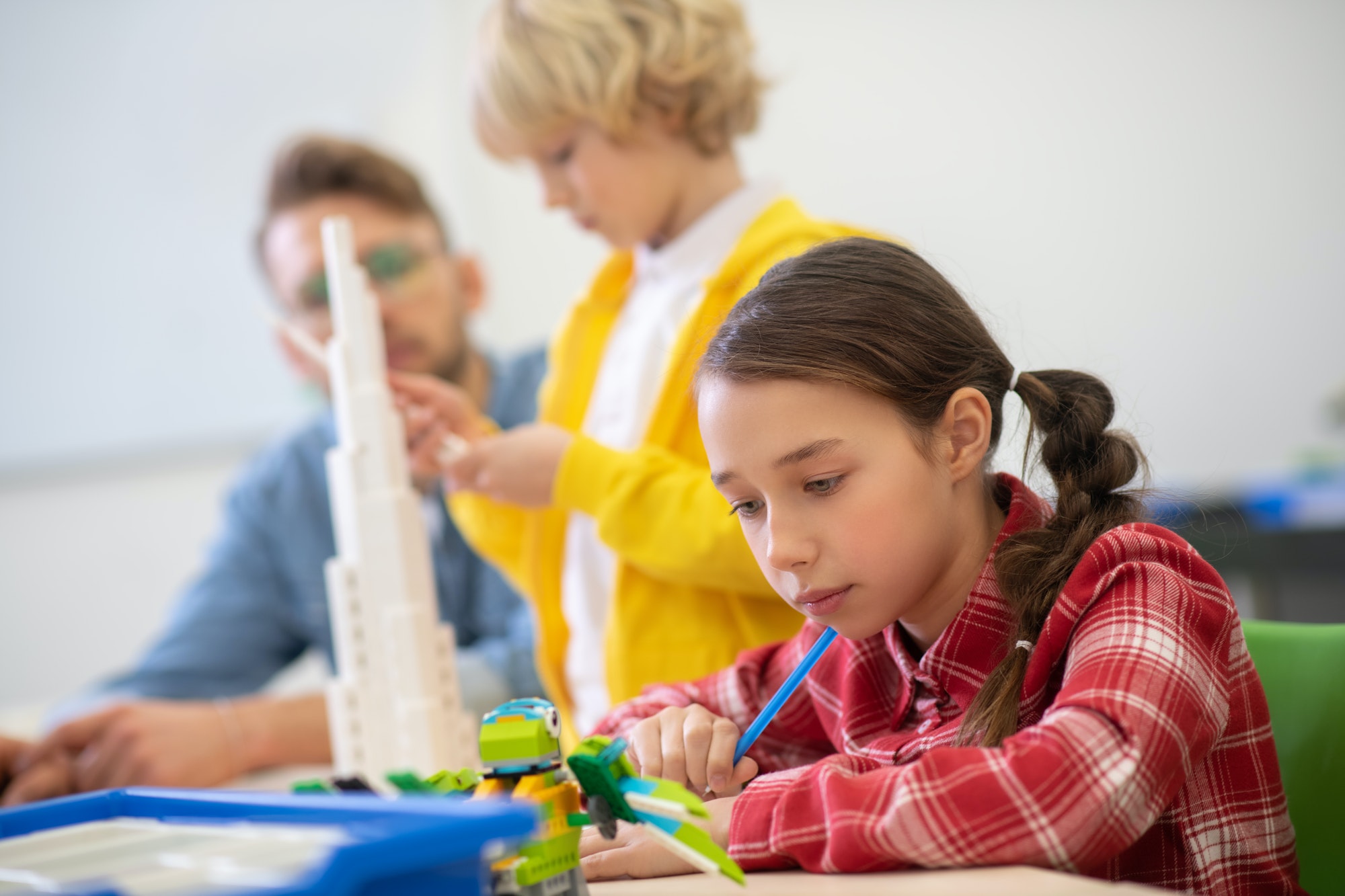 Girl looking at buildable bird, boy building a tower