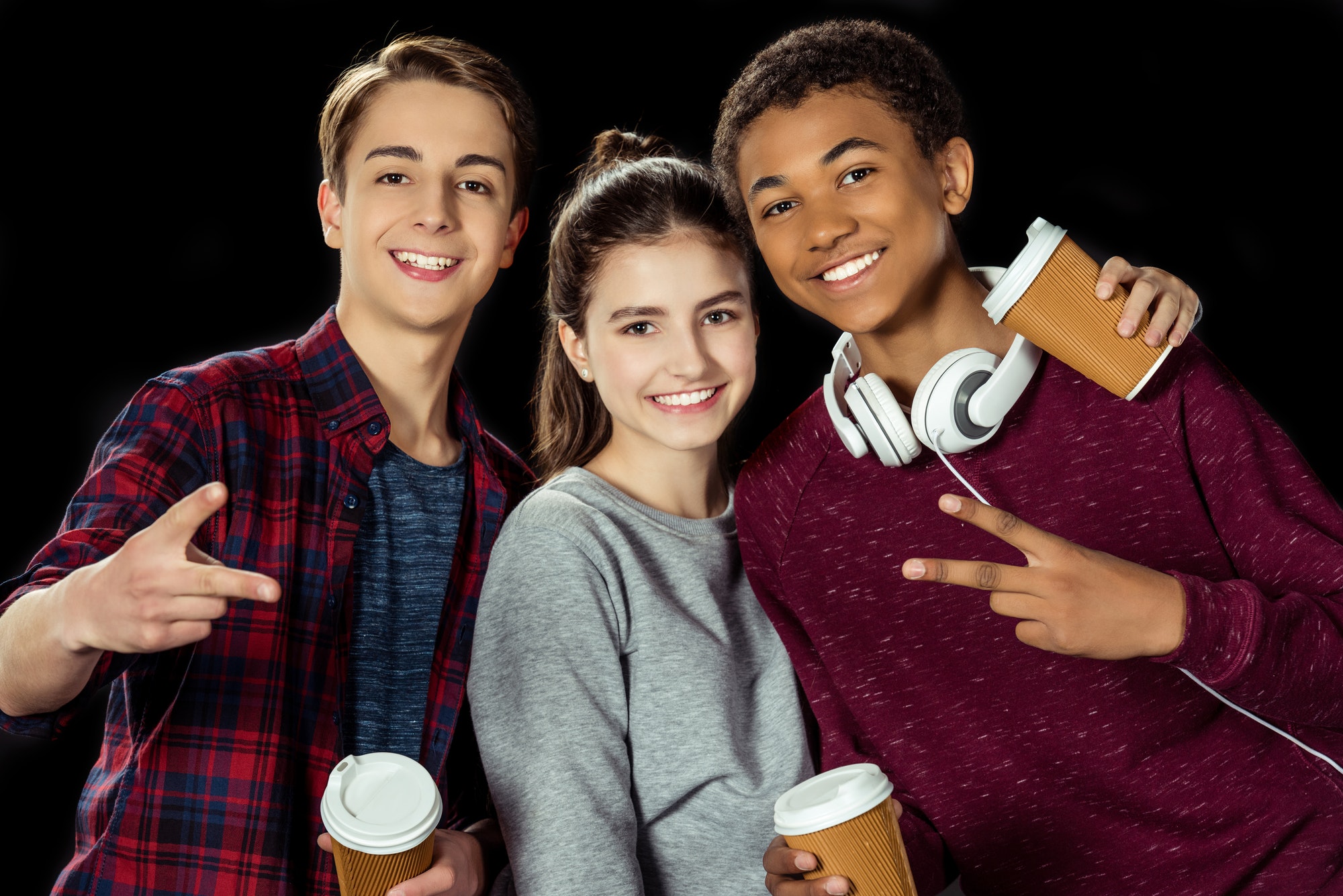 group of teenagers with paper cups of coffee isolated on black