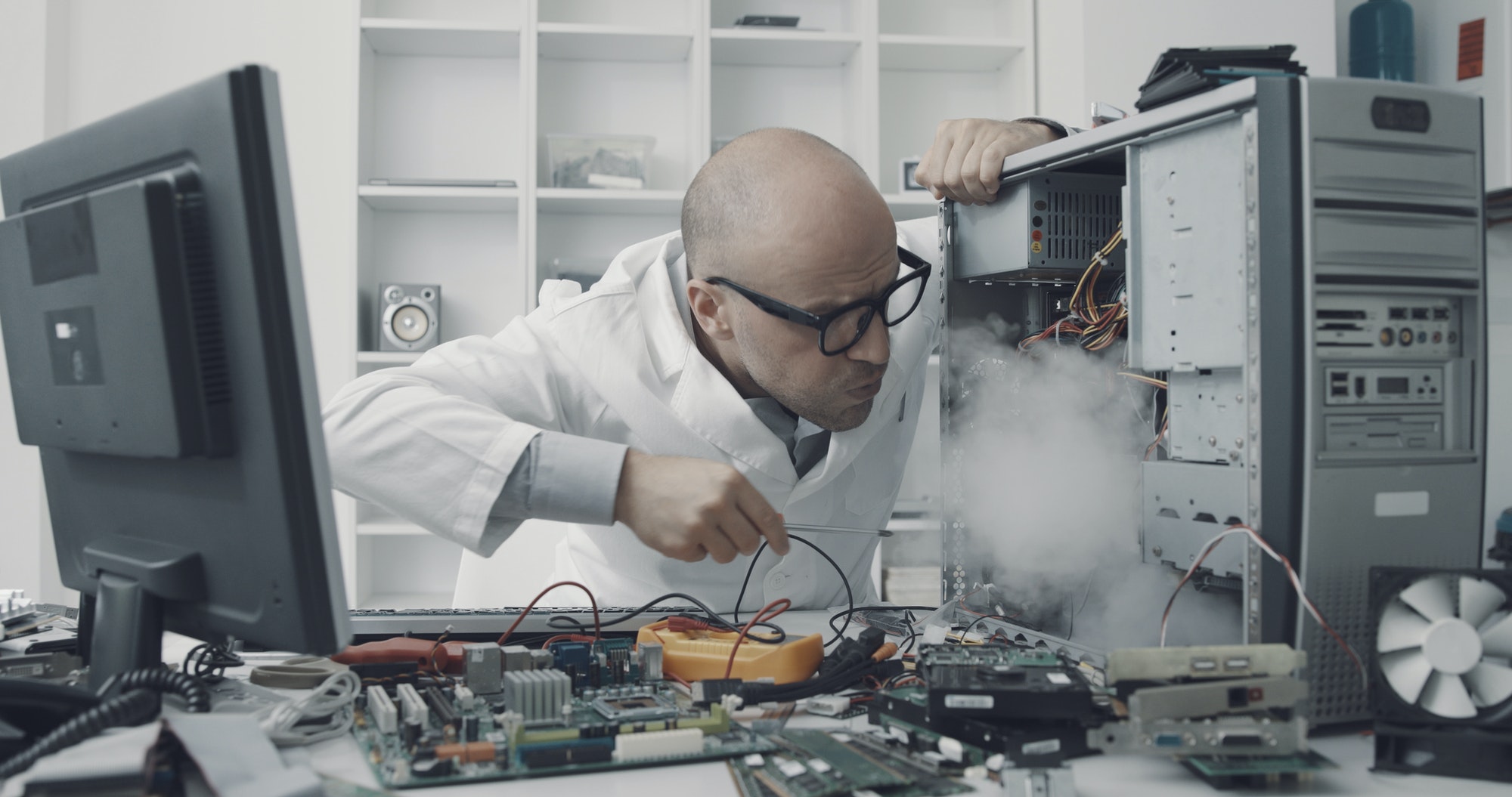 Technician damaging a computer with a screwdriver