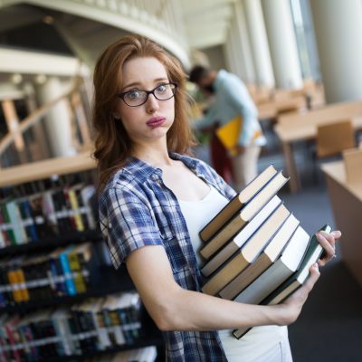 Frustrated teen student girl with books