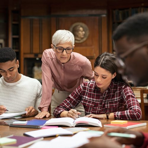 University students studying with teacher