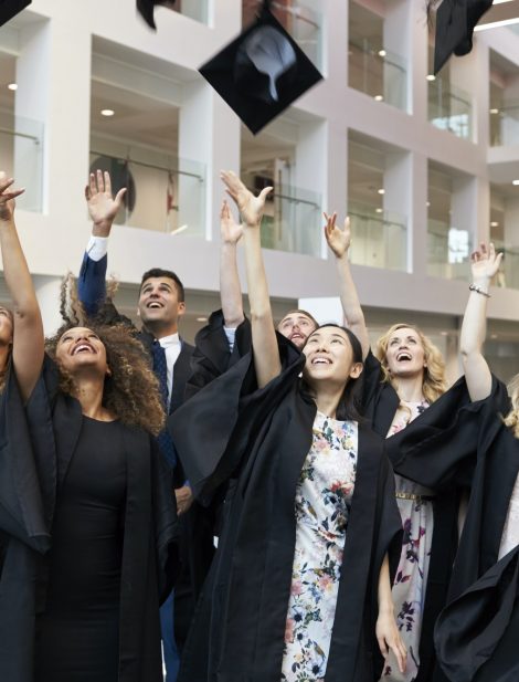 University students throwing their caps in the air on graduation day